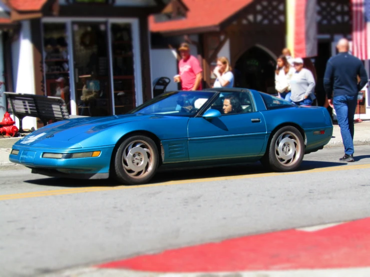 a blue sports car parked along a city street