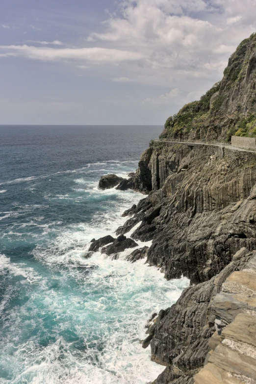 a view of the ocean with waves and rocky shore