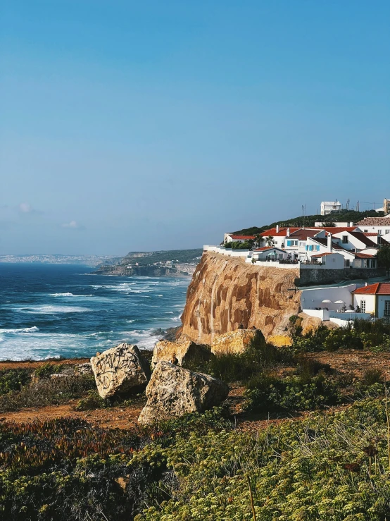 a lighthouse overlooks an ocean view from a hillside