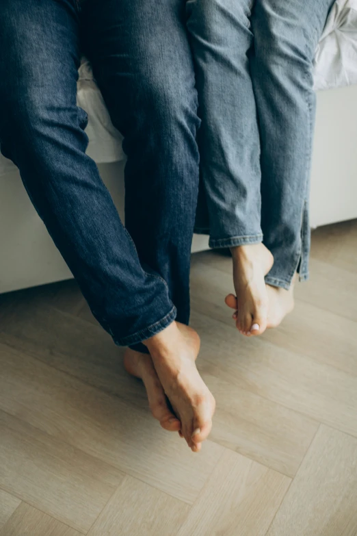 the two people are standing on a hardwood floor