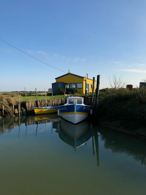 a rowboat is parked in the water with a dock beside it