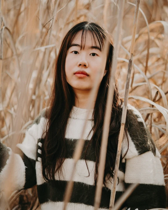 an asian girl with long black hair and a striped sweater