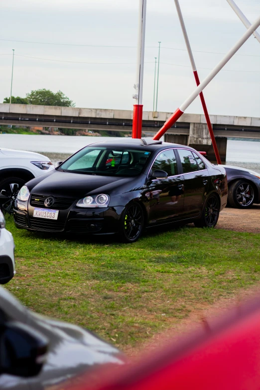 some cars parked on the grass near some metal barriers