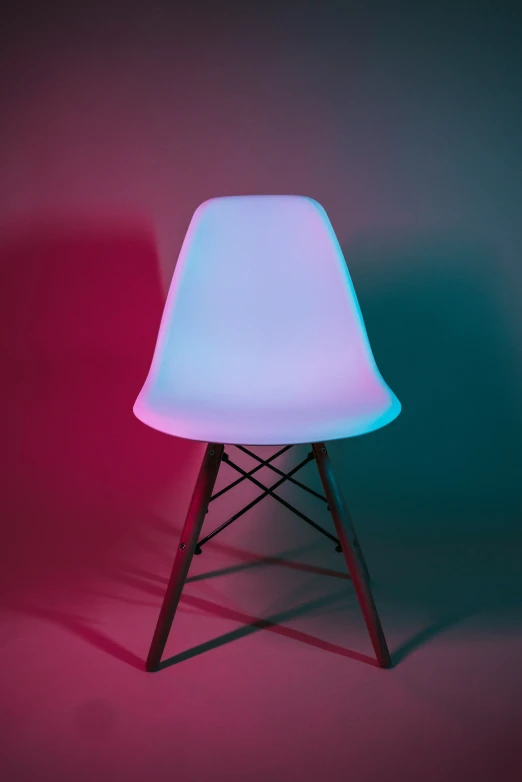 a white chair with black legs and a blue light shining on it