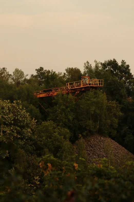 an airplane flying low over trees with a yellow staircase