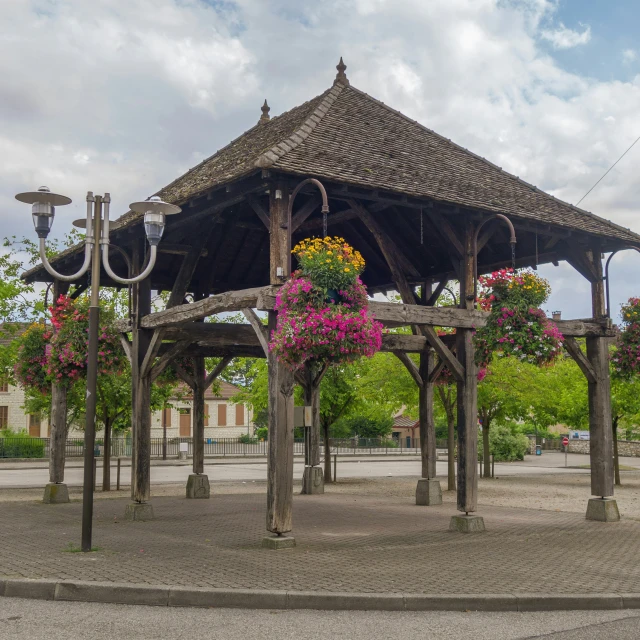 a pavilion with many different flowers hanging off the side