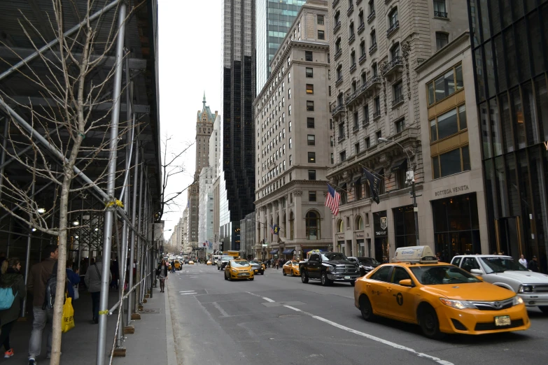 several yellow taxi cabs in a city setting