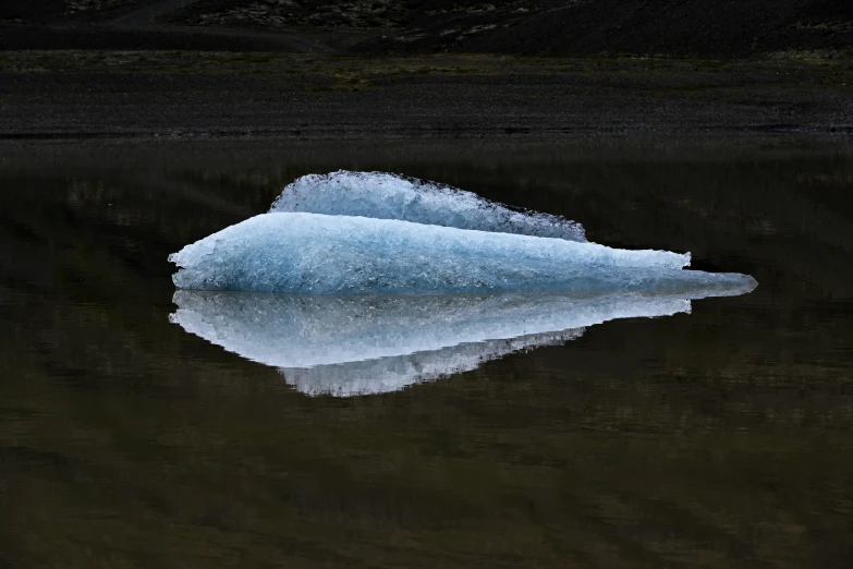 an iceberg floating in a lake near land