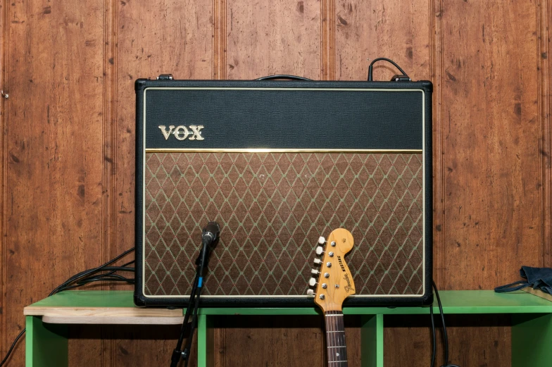 a wooden table topped with an electric guitar and a amp