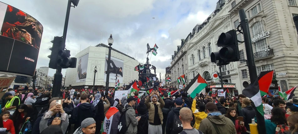 a group of people holding signs in front of buildings