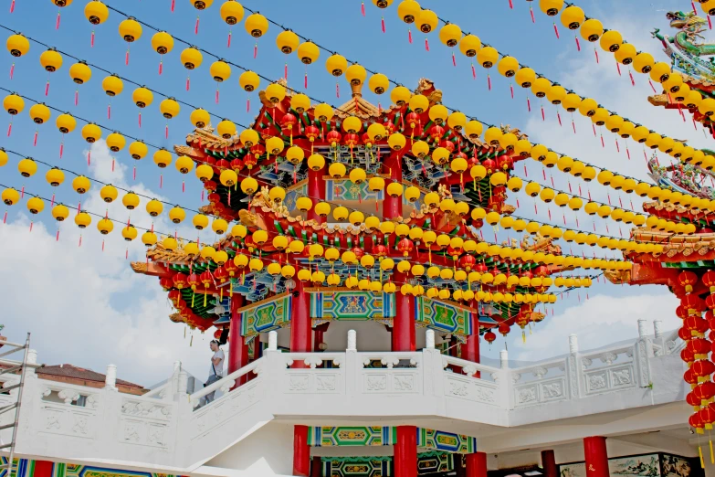 an asian styled pagoda with bright yellow lanterns hanging