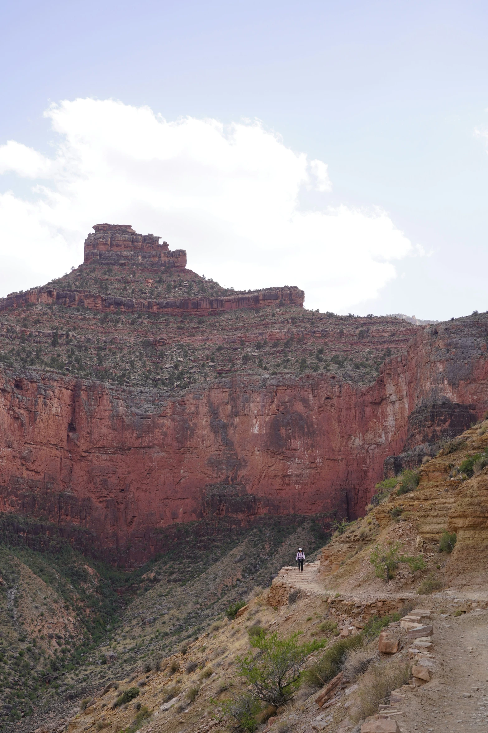 there is a man hiking up a steep hill in a large rocky area