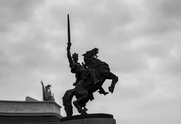 black and white po of statue holding rifle in air