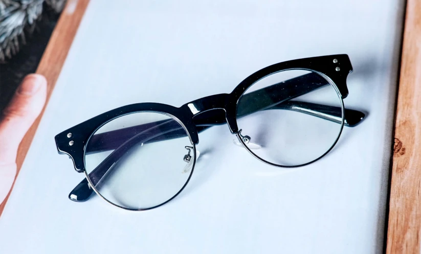 a pair of black eyeglasses are laying on the counter