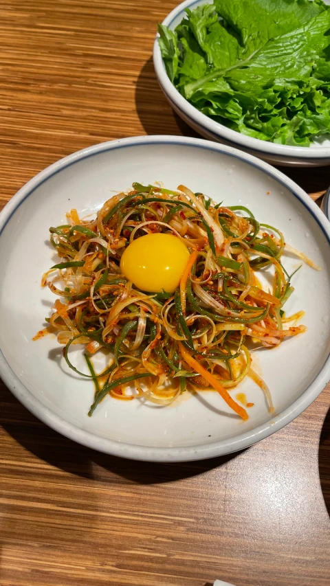 an egg sits in the middle of spaghetti salad