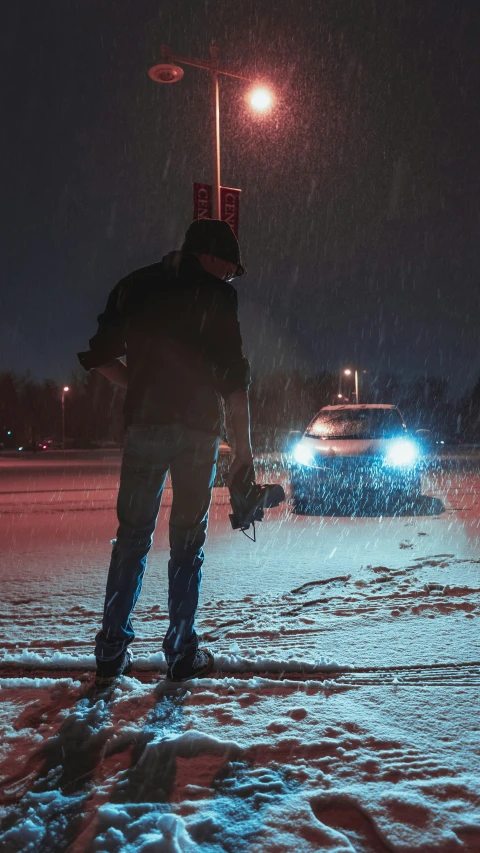 the man is walking in the snow towards a vehicle