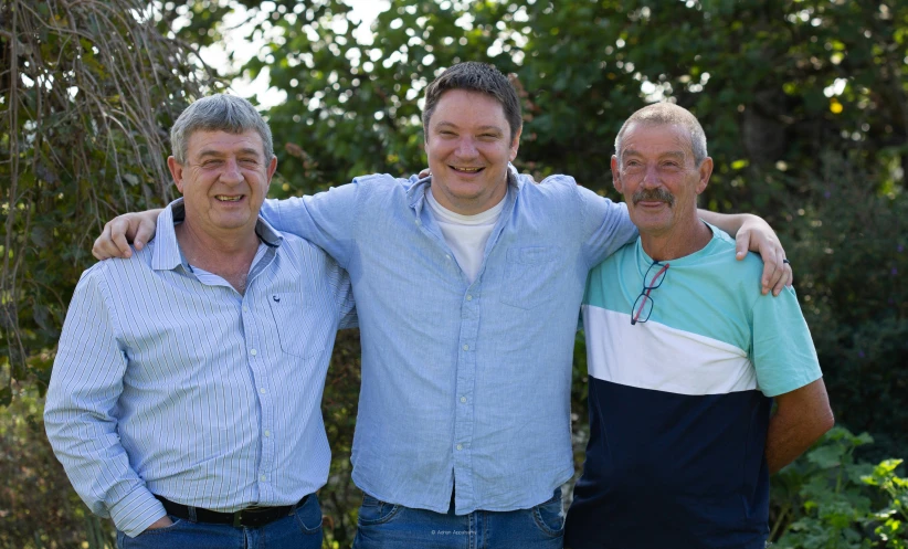 two men pose next to one another for the camera