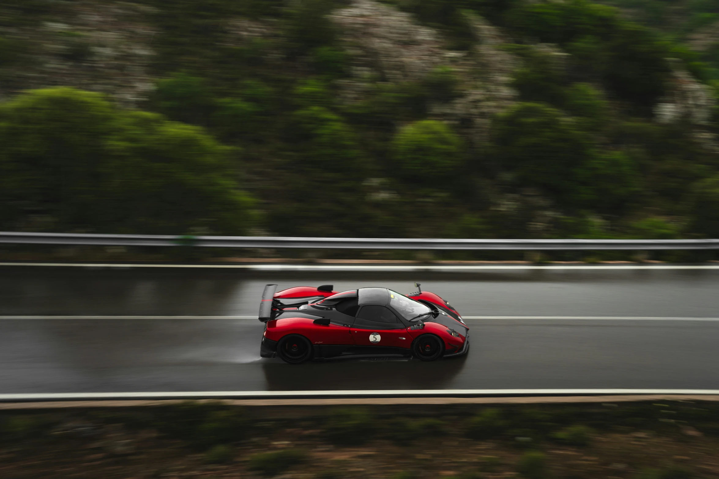 a car on a wet road and some trees