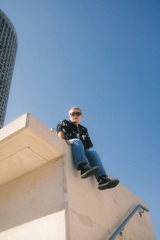 a man sitting on the top of a tall building