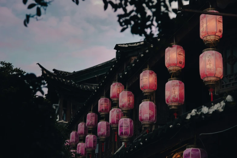 there are many pink lamps hanging from the roof