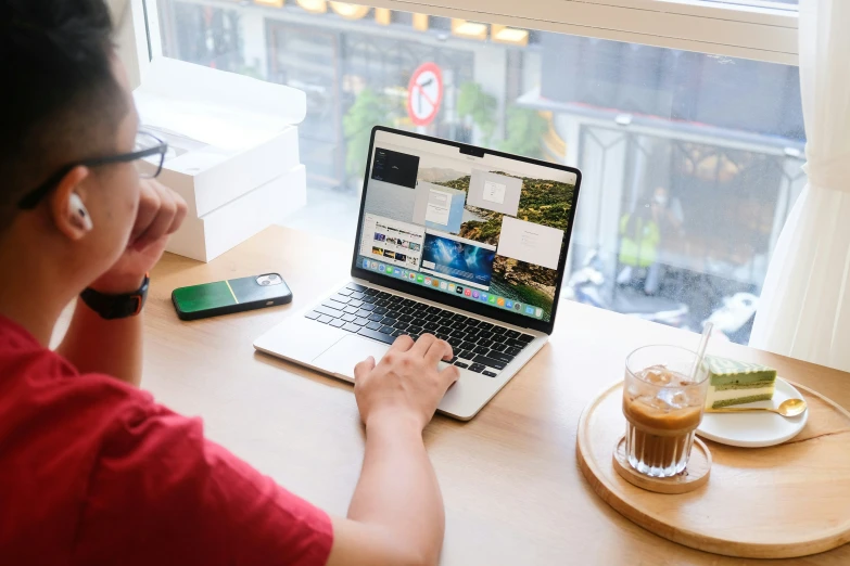 a person sitting in front of a laptop on top of a desk