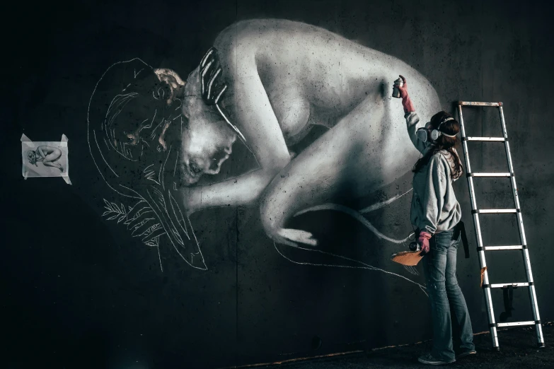 man painting on a wall with his ladder