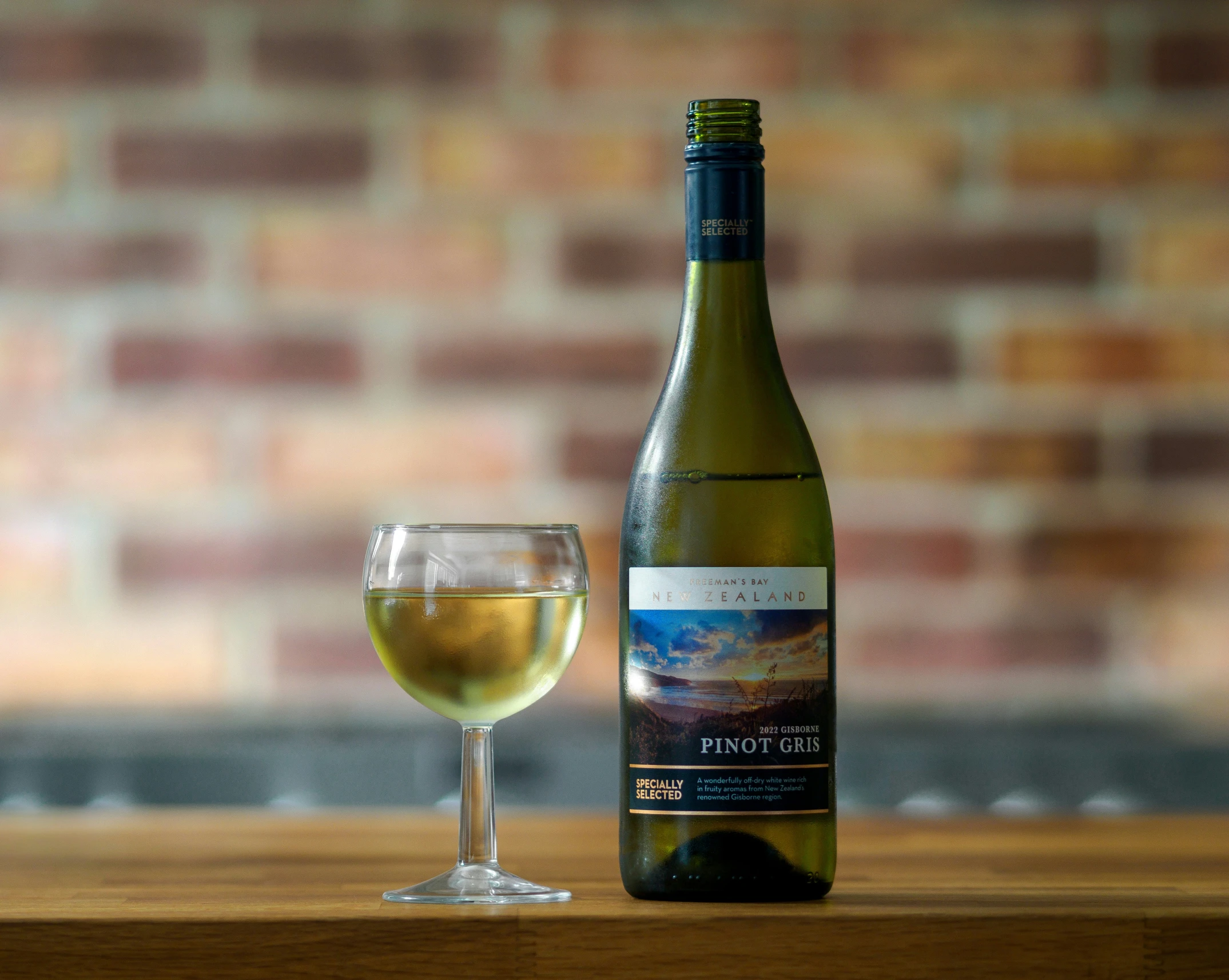 a glass and bottle of wine sitting on a table