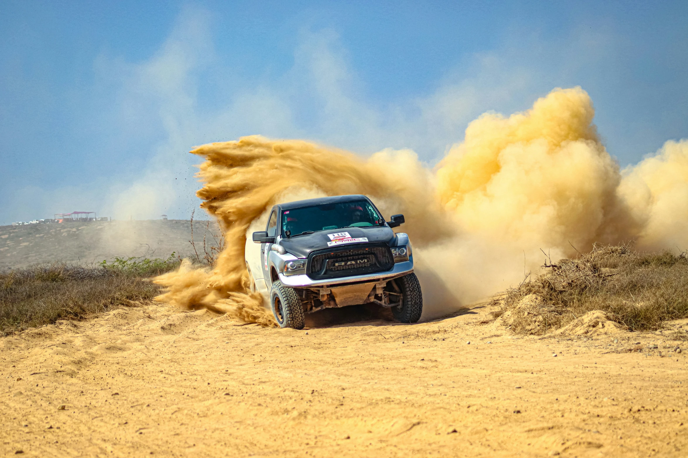 a truck with a giant dust buggy moving around it's track