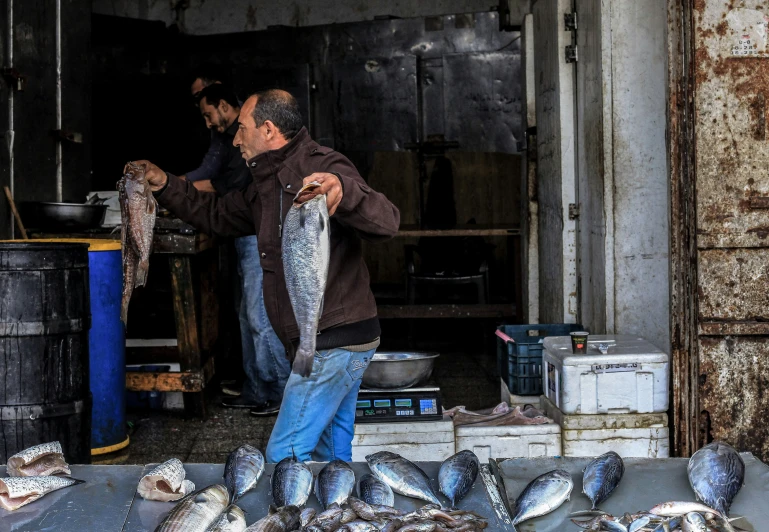 a man holding up some kind of fish