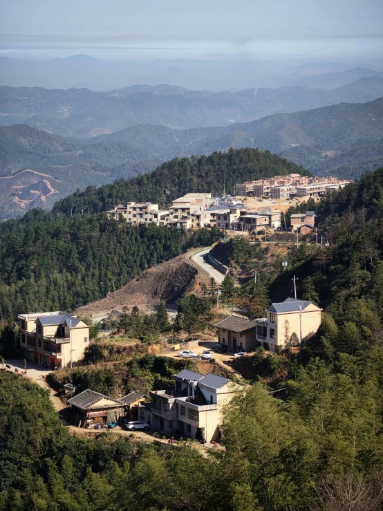 several buildings on a hillside with a city in the distance