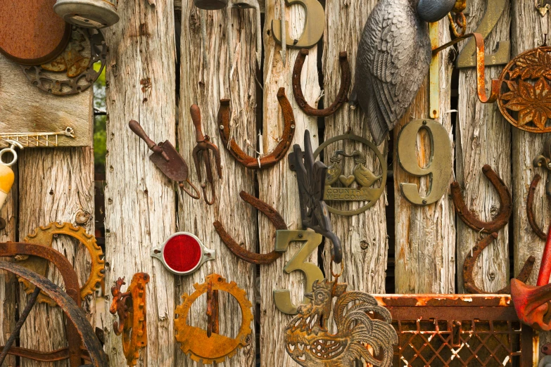 a bunch of decorative items placed together on the wooden fence