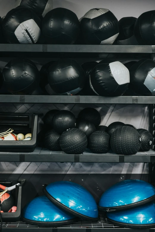 there are black, blue and white balls stacked up on shelves