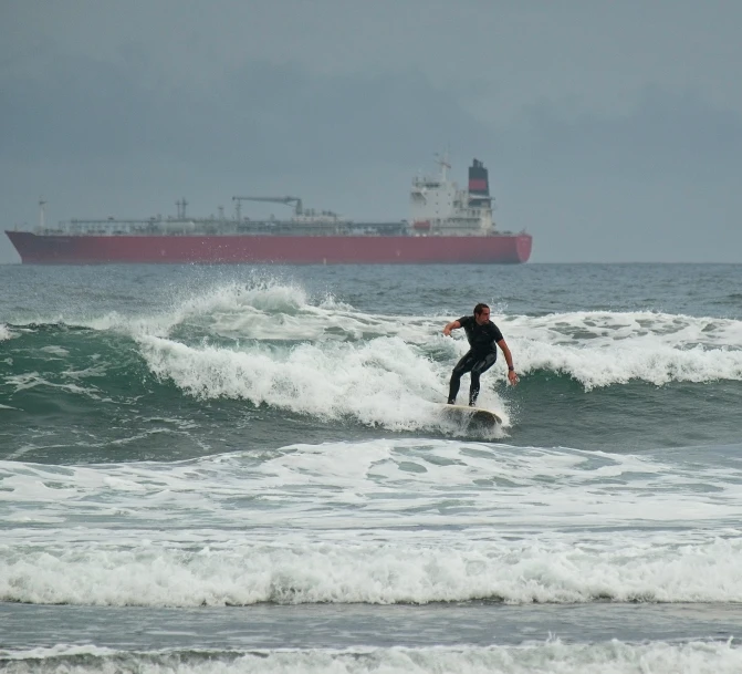 a man riding a surfboard on top of a wave