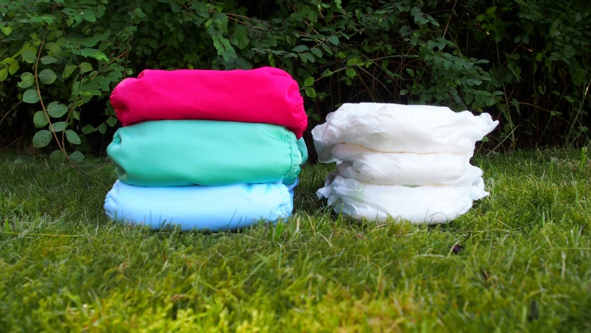 three wet bags and three towels sitting on the grass