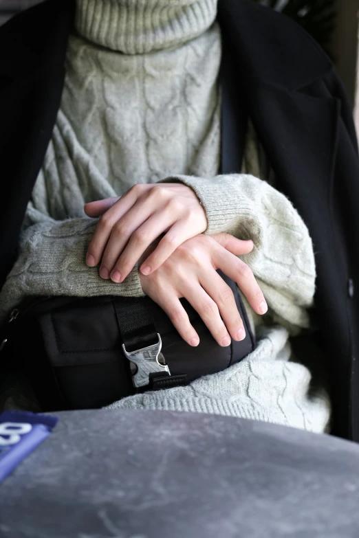 a person that is sitting down with her hand on the pocket