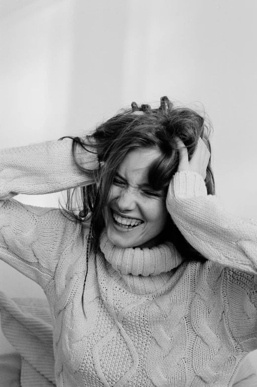 black and white po of a woman putting on her hair