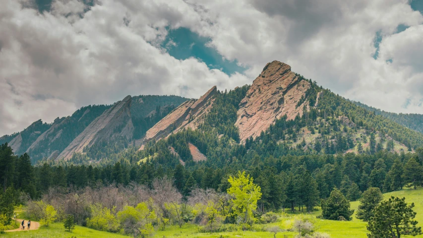 a lone horse walking in the distance while the sun is shining on the mountains