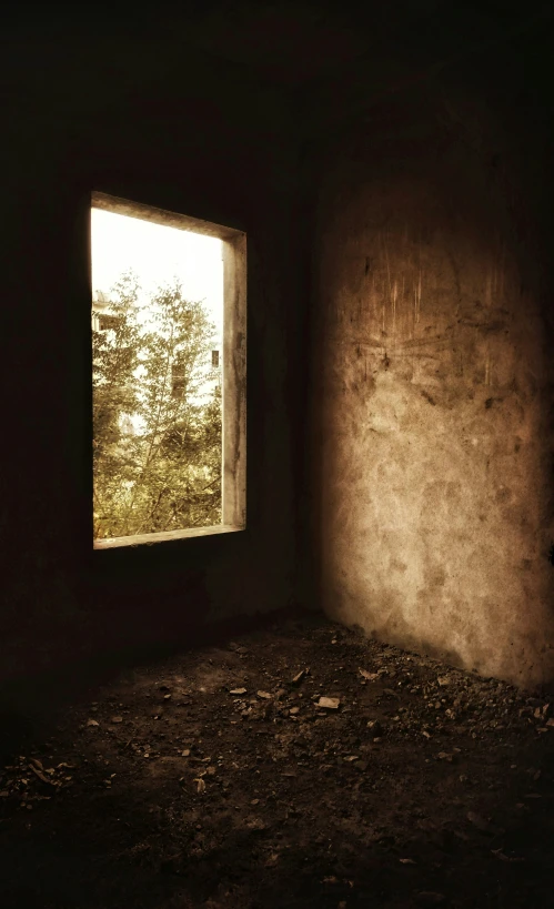a bare room with a window and dirt floor