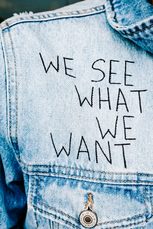 the words we see what we want on an oversized jean jacket
