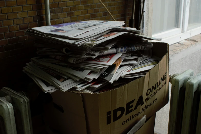 a cardboard box with a bunch of newspapers in it