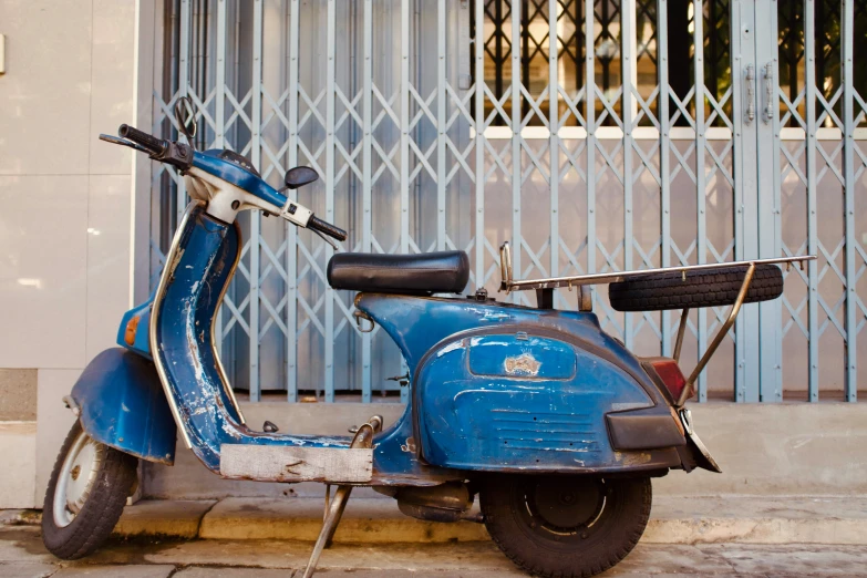 a blue scooter parked on the side of the street