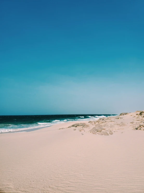 the sandy beach has very little sand and waves