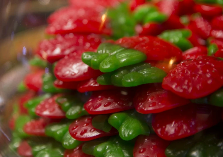 small, red and green peppers are piled on top of each other