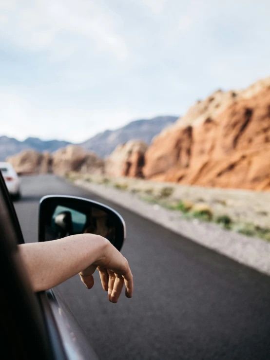 someone sticking their hand out of the window of a car