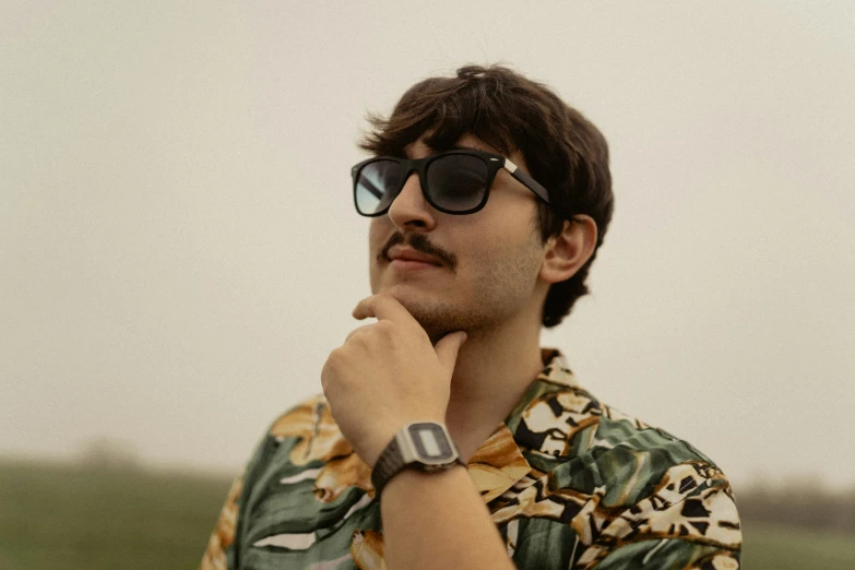 a man wearing sunglasses and a floral shirt