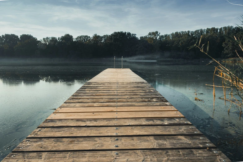 a dock that has some water and grass on it