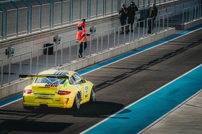 a car on a race track next to a man