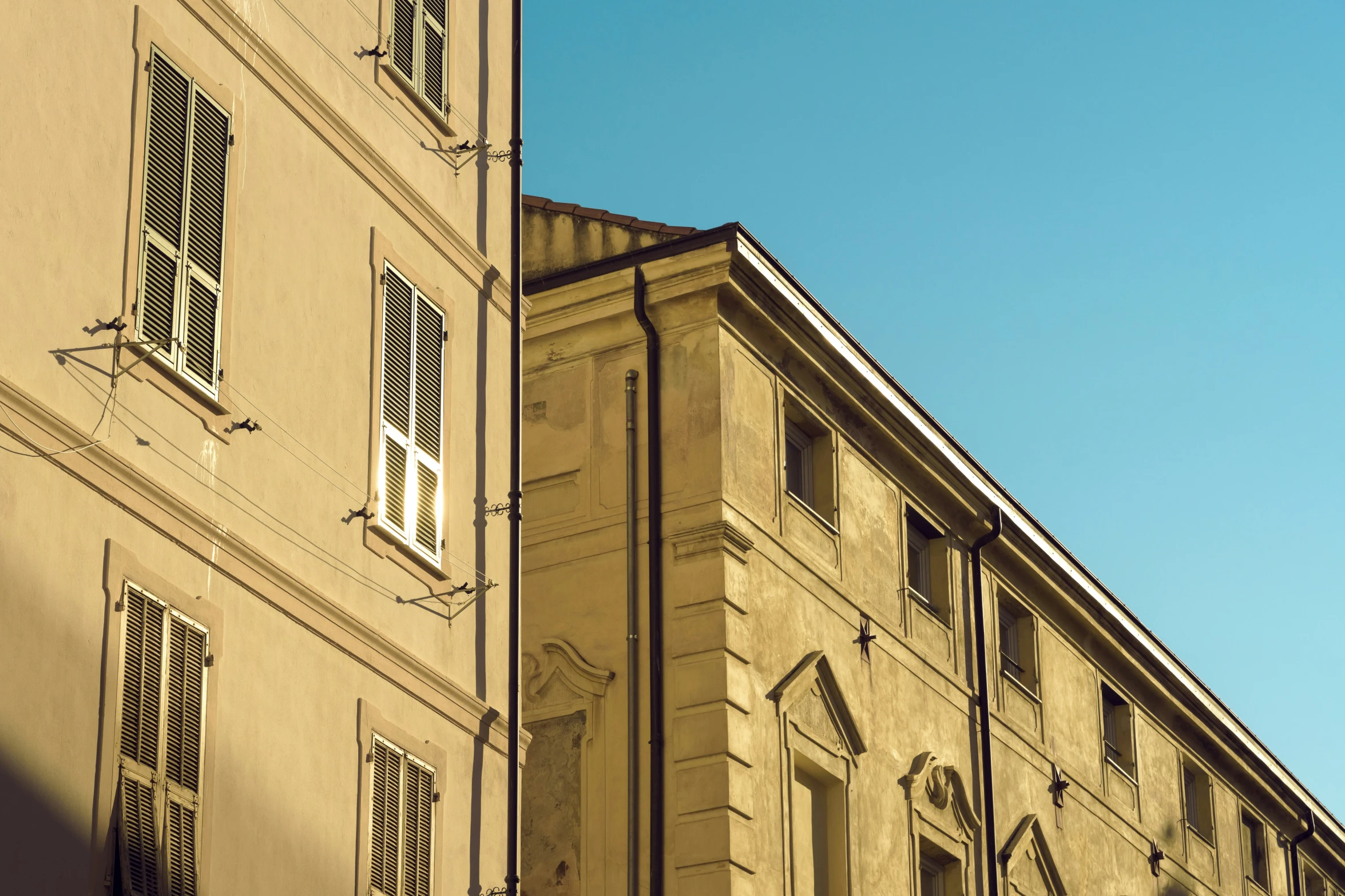 a building is shown with two windows and one has shutters open