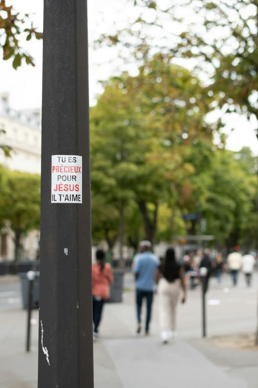 a pole is on the side walk with a sign