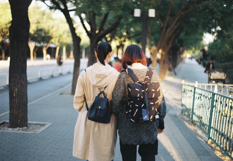 two people walking down a road in the city